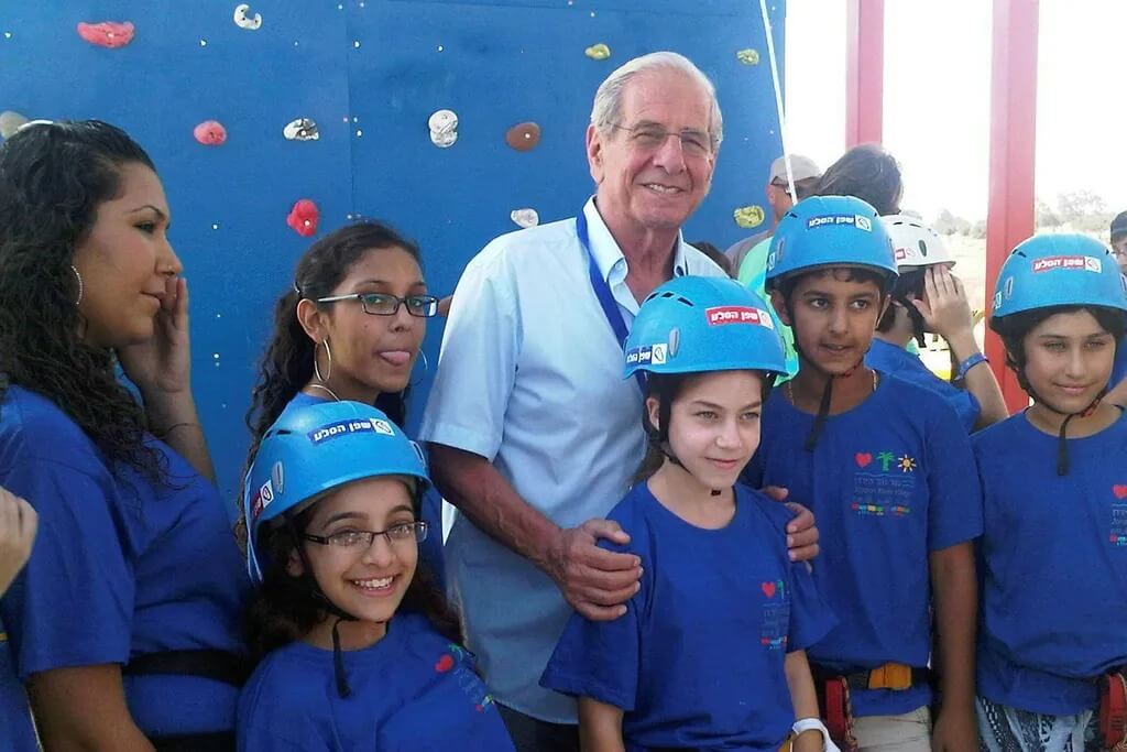 Chaim Topol poses with children at the Jordan River Village, which he helped establish and served as chairman of its board.