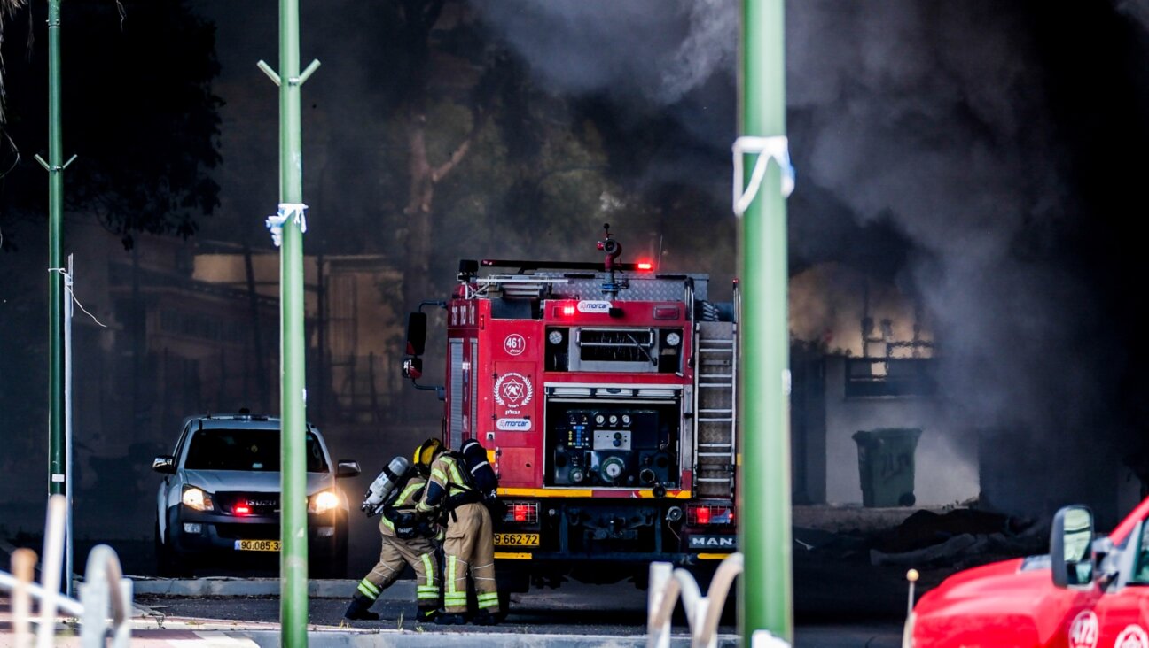 Firefighters try to extinguish a fire caused after a rocket sent from Lebanon hit near the Israeli town of Shlomi, April 6, 2023. (Fadi Amun/Flash90)