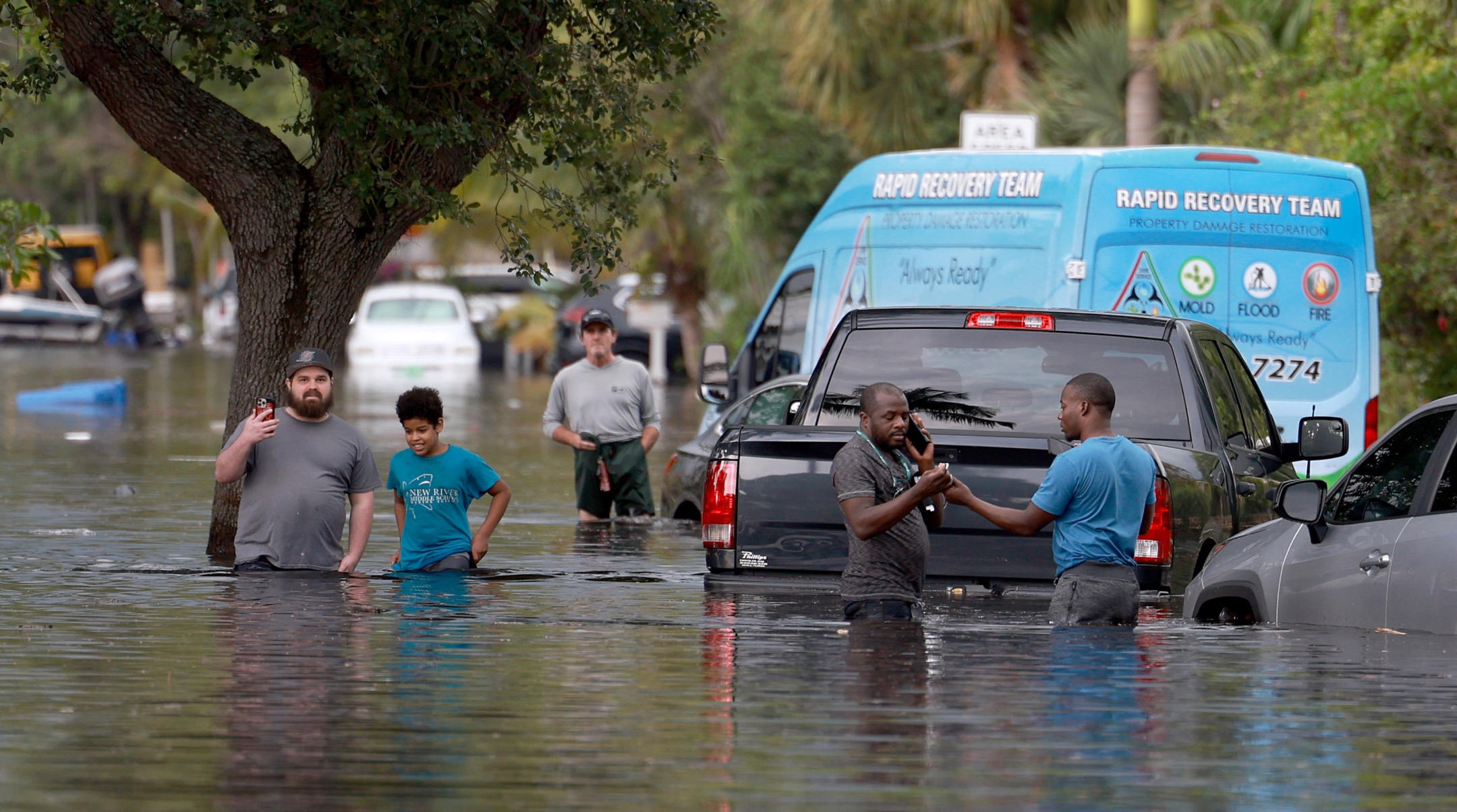 People walk through a flooded neighborhood in Fort Lauderdale, Florida, April 13, 2023. (Joe Raedle/Getty Images)