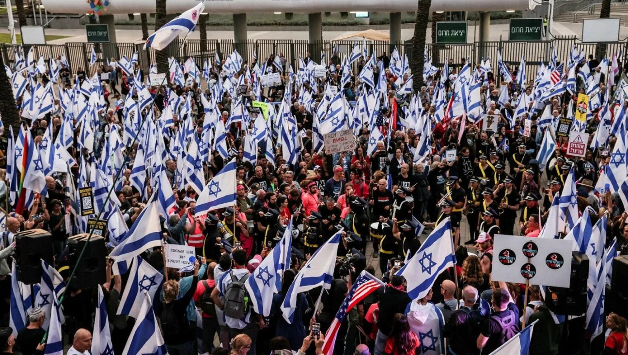 Israeli protesters gather outside the Jewish Federations of North America conference in Tel Aviv, where they angered some in the anti-government movement by extending invitations to Prime Minister Benjamin Netanyahu and far-right Knesset member Simcha Rothman.
