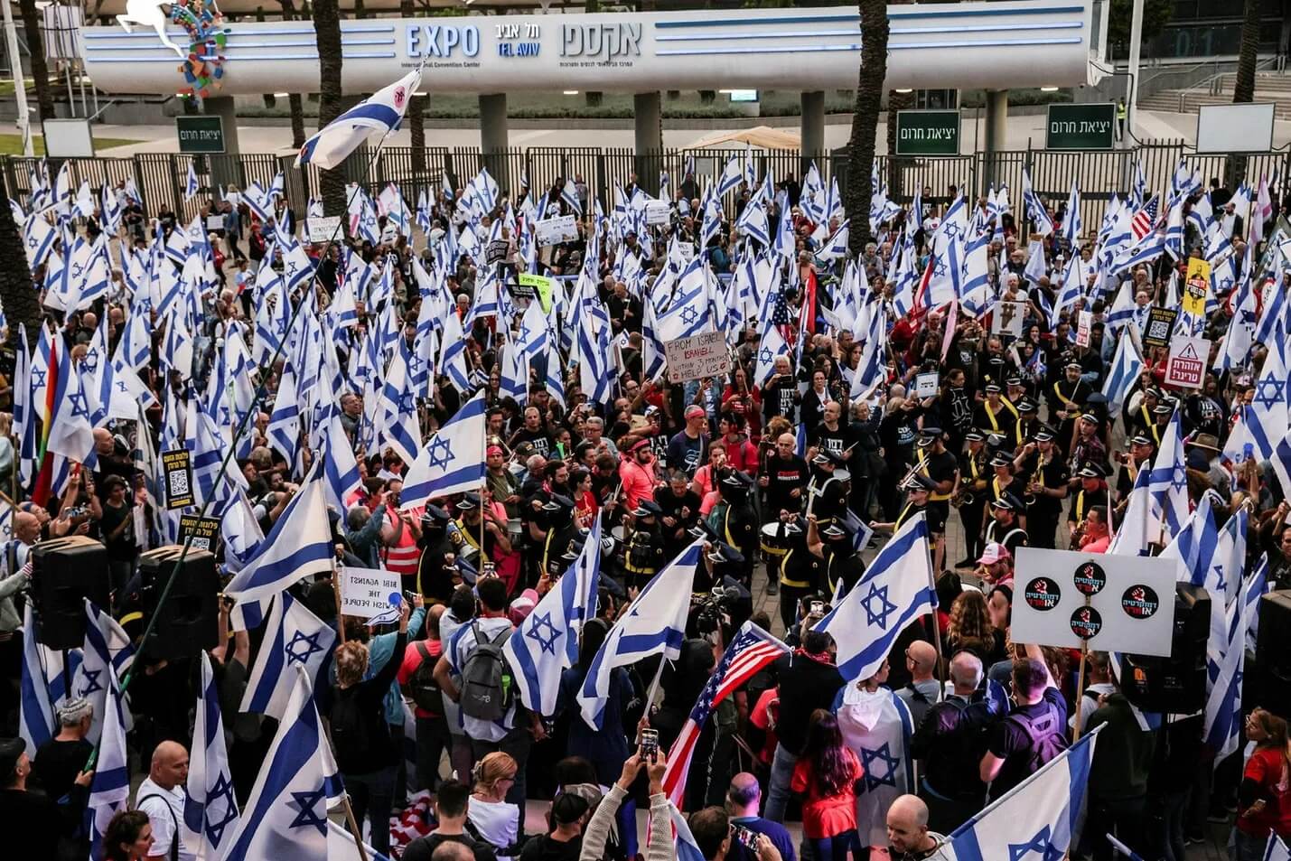 Israeli protesters gather outside the Jewish Federations of North America conference in Tel Aviv, where they angered some in the anti-government movement by extending invitations to Prime Minister Benjamin Netanyahu and far-right Knesset member Simcha Rothman.