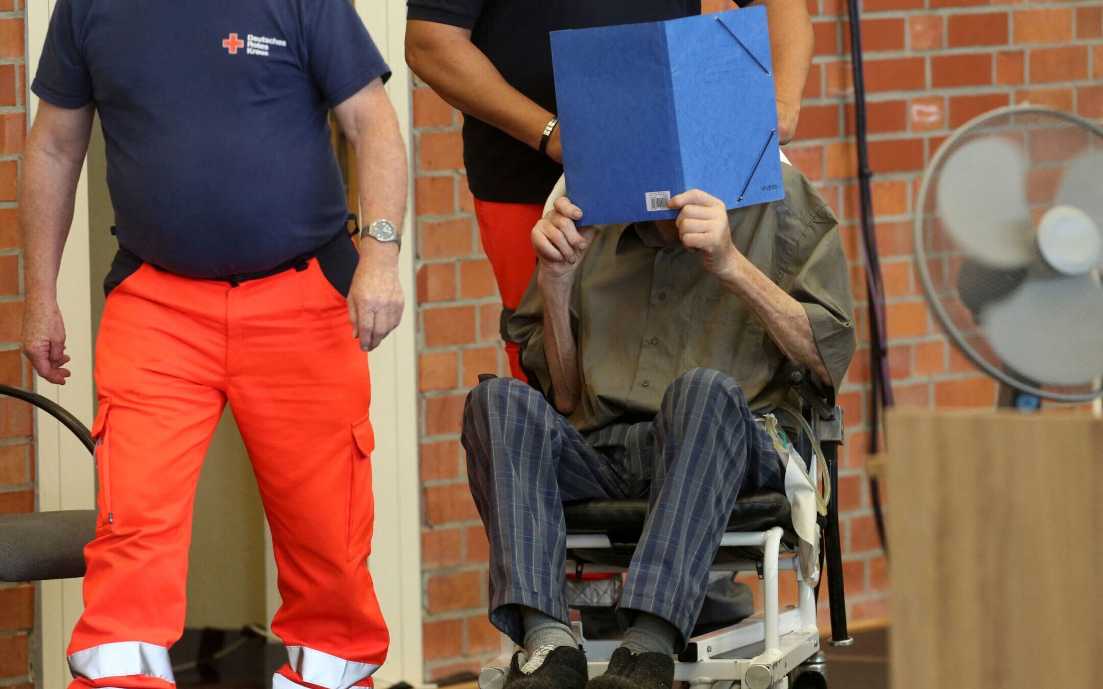 Former Nazi concentration camp guard Josef Schütz hides his face with a folder as he arrives to a makeshift courtroom in Brandenburg-Havel to hear the verdict in his trial, June 28, 2022. (Adam Berry/AFP via Getty Images)