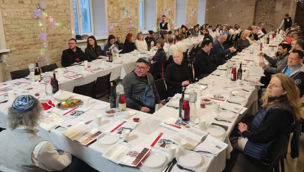 Guests at a seder in Kyiv, Ukraine, including many families from heavily damaged Kharkiv, sit around the seder table on the first night of Passover, April 5, 2023. (Marcel Gascon Barbera)