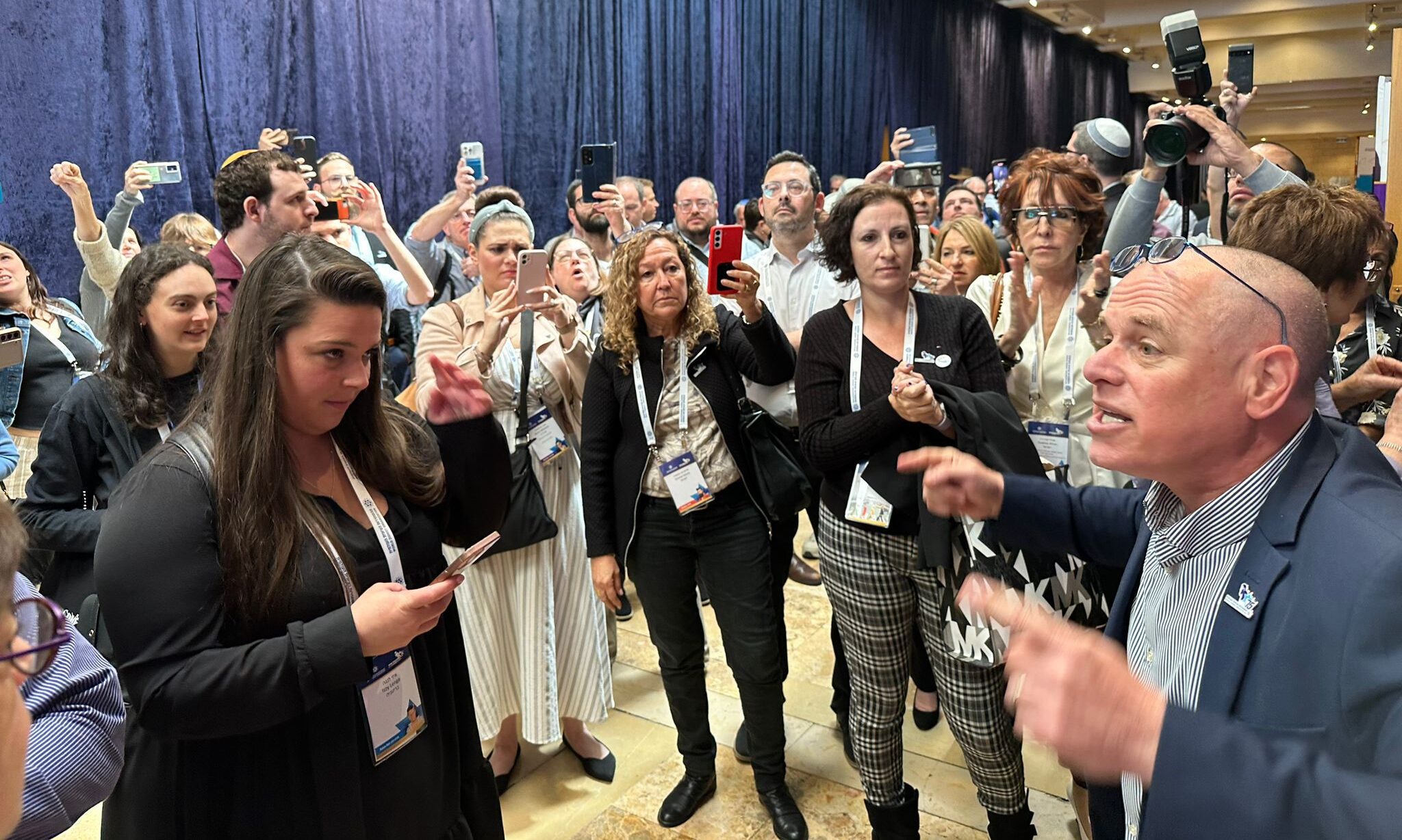 World Zionist Organization Vice Chairman Yizhar Hess speaks to protestors assembled outside the room where right-wing Knesset member Simcha Rothman was holding a meeting, April 21, 2023. (Courtesy)