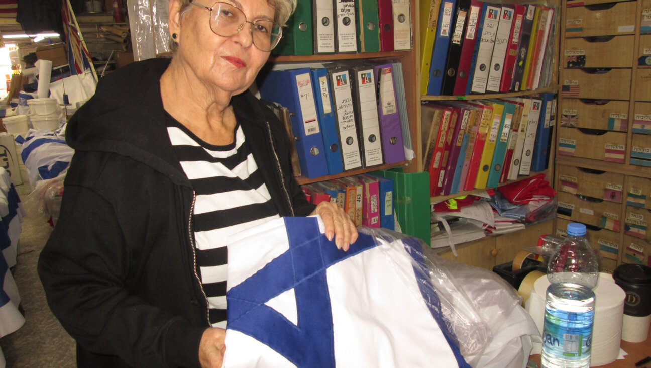 Hadassah Berman, the 75-year-old daughter-in-law of company's founders, holds a flag whose Star of David is hand-sewn onto the fabric. 