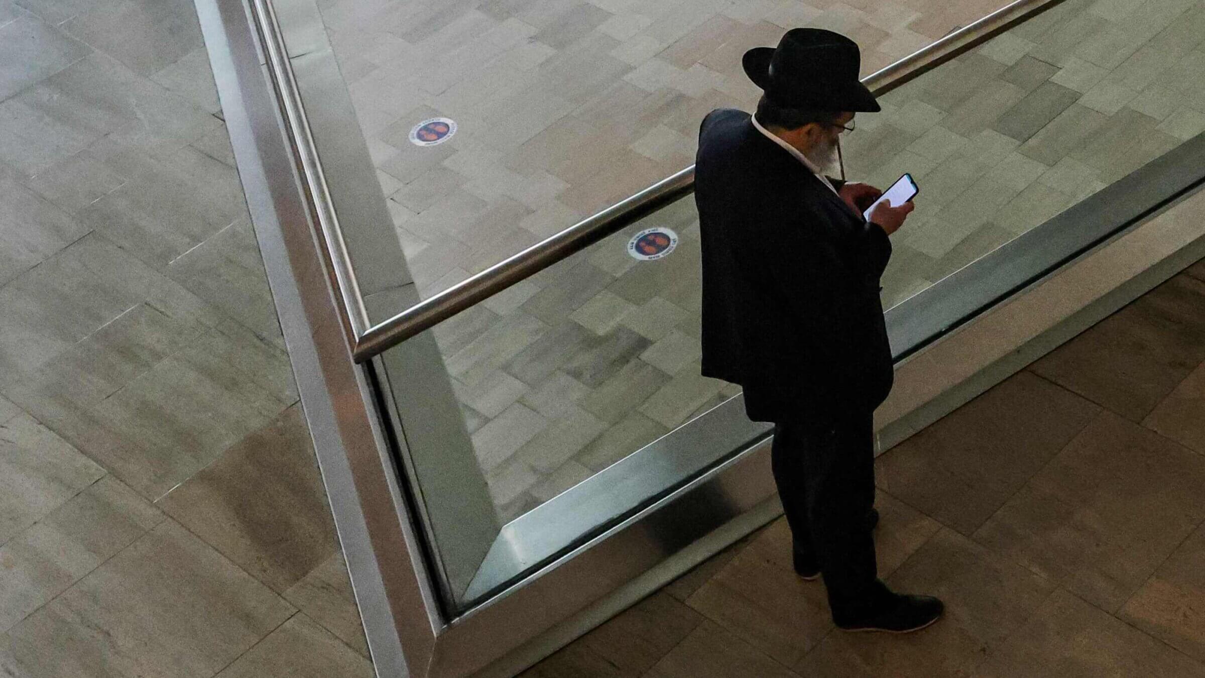 A Haredi Orthodox man browses his phone.