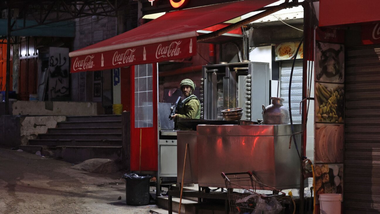 An Israeli soldier stands guard in the Israeli-occupied West Bank city of Hawara in December. The town became notorious for settler violence after a February riot. 