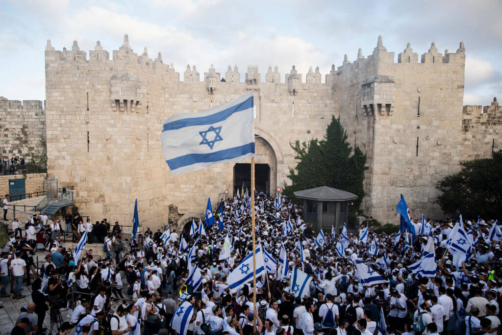 Israeli jews hold the Israeli flag as they are marching in Jerusalem's old city muslim quarter on May 18, 2023 in Jerusalem, Israel. (Amir Levy/Getty Images)
