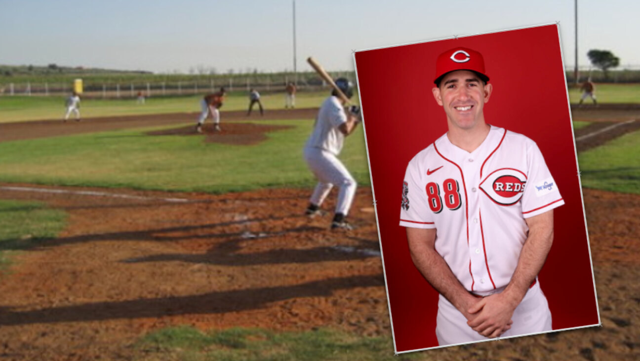 Alon Leichman, a new assistant coach for the Cincinnati Reds. Background is the baseball field on which he learned to play, the first in Israel, on Kibbutz Gezer.
