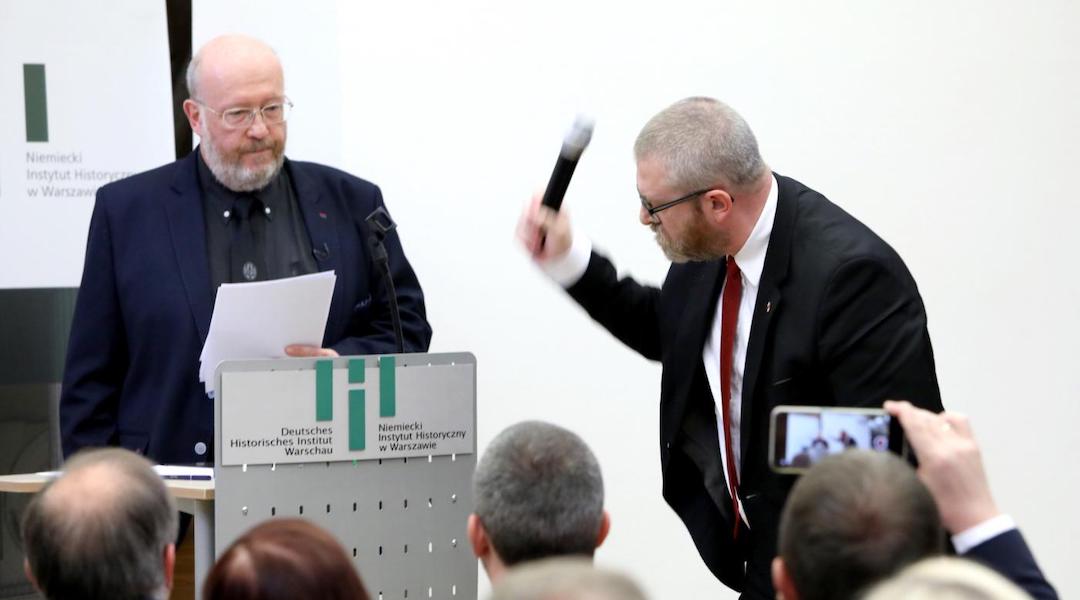 Polish-Canadian historian Jan Grabowski stands at the podium for a planned lectured as far-right lawmaker Grzegorz Braun of Poland’s Confederation party grabs the microphone and smashes it at the German Historical Institute in Warsaw, Poland, May 30, 2023. (Courtesy of Jan Grabowski)