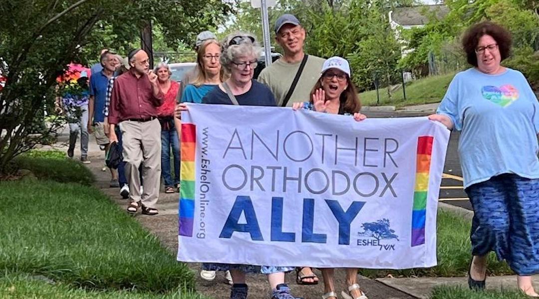 Members and allies of Eshel, an advocacy group for LGBTQ Orthodox Jews and their families, march in Highland Park, New Jersey, as Pride flags are restored to a public street after they had been removed at the request of Orthodox rabbis, June 26, 2023. (Courtesy of Eshel)