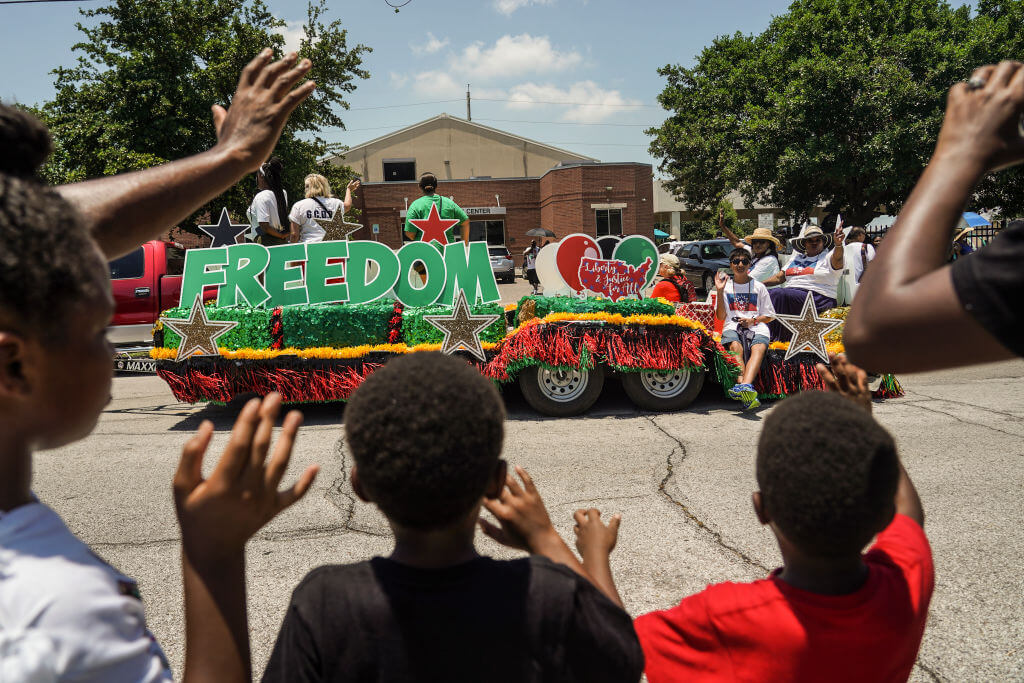 Spectators watch Juneteenth Parade commemorating the end of slavery in the United States on June 19, 2021 in Galveston, Texas. Juneteenth celebrations, now recognized as a federal holiday, are taking place around the country in recognition of the emancipation of enslaved African Americans.