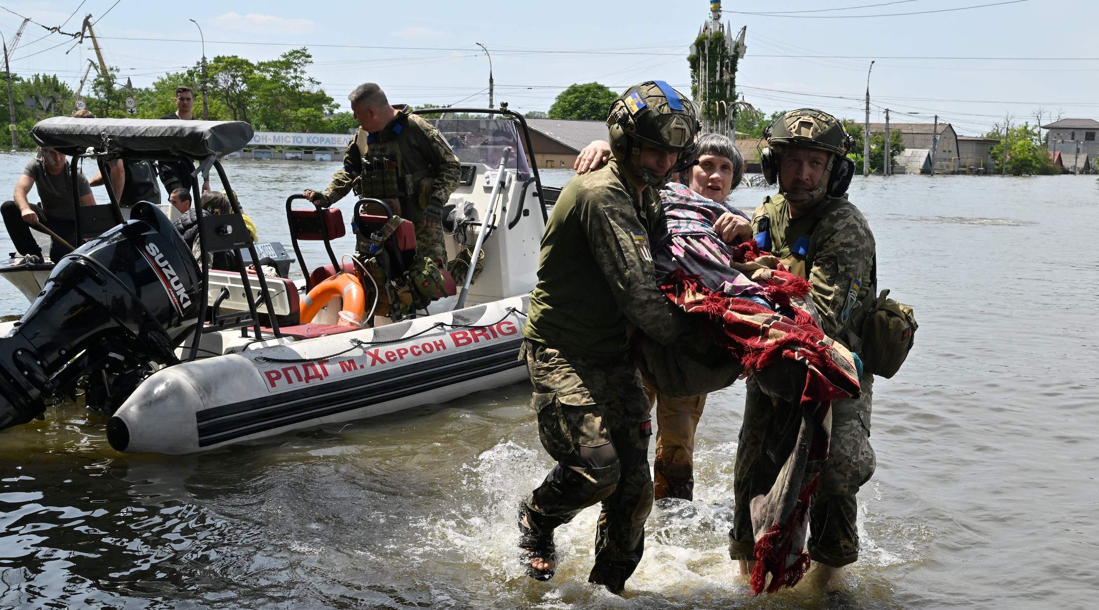 Ukrainian servicemen help a local resident during an evacuation from a flooded area in Kherson, Ukraine, June 8, 2023. (Genya Savilov/AFP via Getty Images)