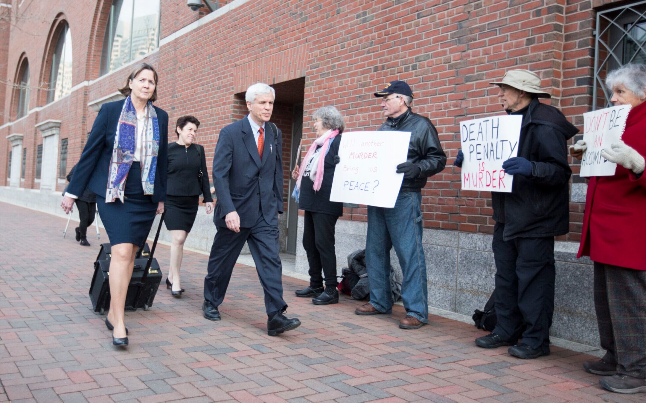 Defense attorney Judy Clarke, left, passes protesters as she arrives at a federal courthouse during the trial of Boston Marathon bombing suspect Dzhokhar Tsarnaev in Boston, April 6, 2015. (Scott Eisen/Getty Images)
