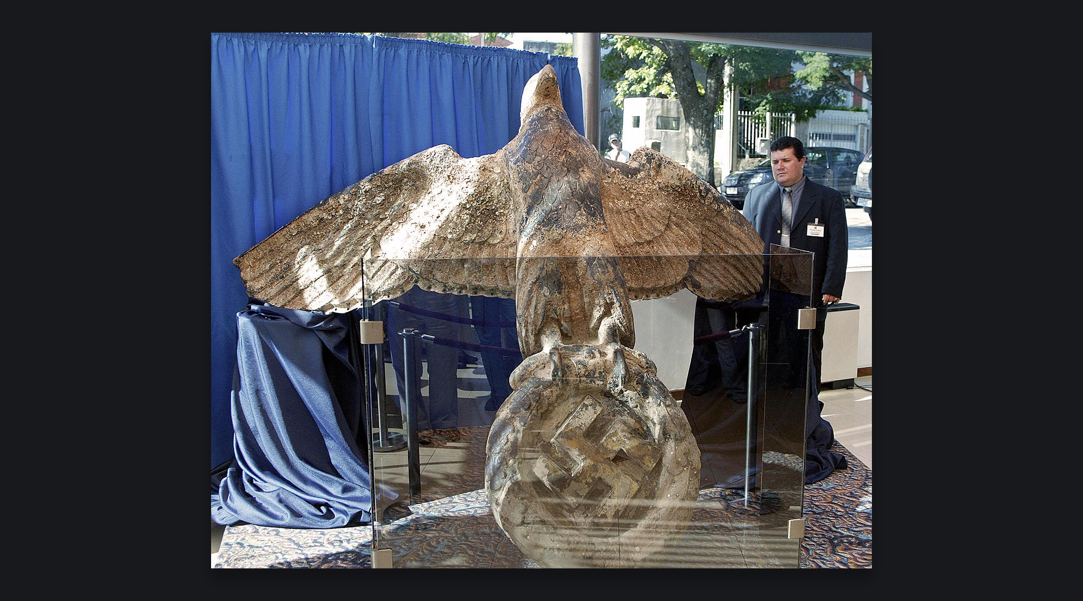 A security guard looks at the bronze eagle recovered from the stern of the German Graf Spee battleship, on display in Montevideo, Uruguay, Feb. 13, 2006. (Miguel Rojo/AFP via Getty Images)