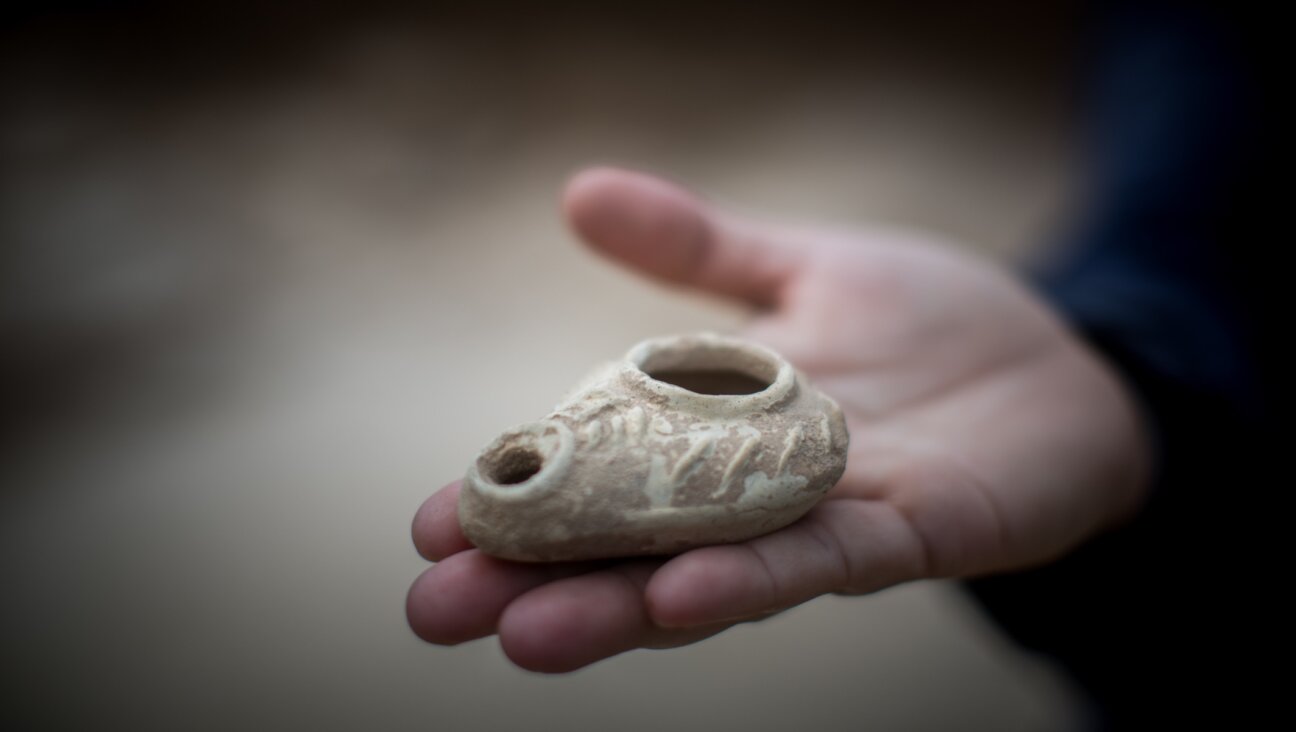 Annette Nagar from the Israel Antiquities Authority shows an oil lamp tool as she stands in an ancient Byzantine church dating from 1,500 years ago discovered during an archaeological rescue excavation near Jerusalem, June 10, 2015. (Yonatan Sindel/Flash90)