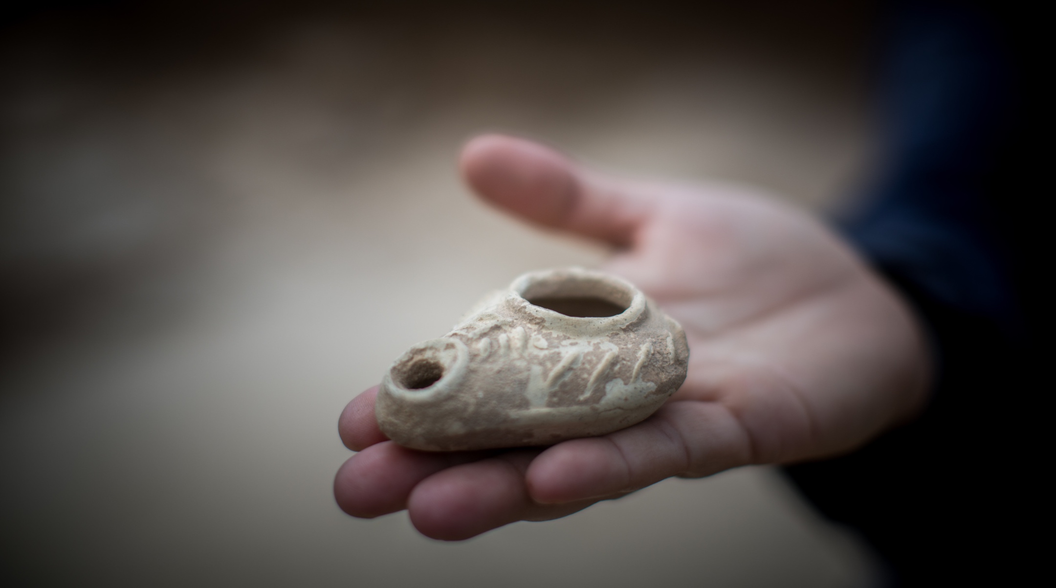 Annette Nagar from the Israel Antiquities Authority shows an oil lamp tool as she stands in an ancient Byzantine church dating from 1,500 years ago discovered during an archaeological rescue excavation near Jerusalem, June 10, 2015. (Yonatan Sindel/Flash90)