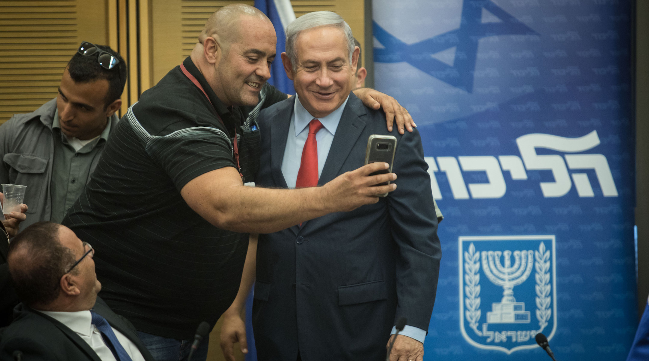 Prime Minister Benjamin Netanyahu poses for a selfie with Itzik Zarka, a Likud activist, during a Likud Party faction meeting at the Knesset, Israel’s parliament, on July 9, 2018. (Hadas Parush/Flash90)