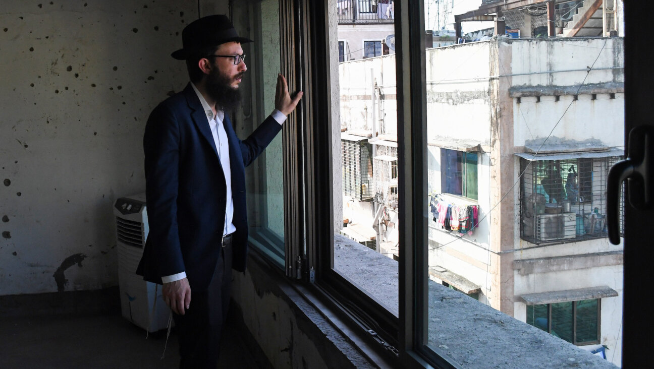 Rabbi Israel Kozlovsky, director of Mumbai’s Chabad center, looks out of a window of the center, in front of a wall pock-marked with bullet holes from the 2008 terror attack. (Ashish Vaishnav/SOPA Images/LightRocket via Getty Images)