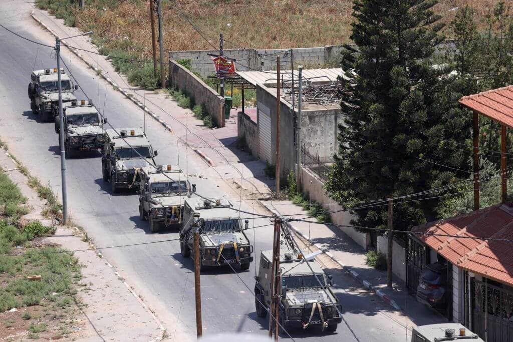 Israeli military armoured vehicles advance on a road during an operation in Jenin city in the occupied West Bank, on July 3, 2023. 