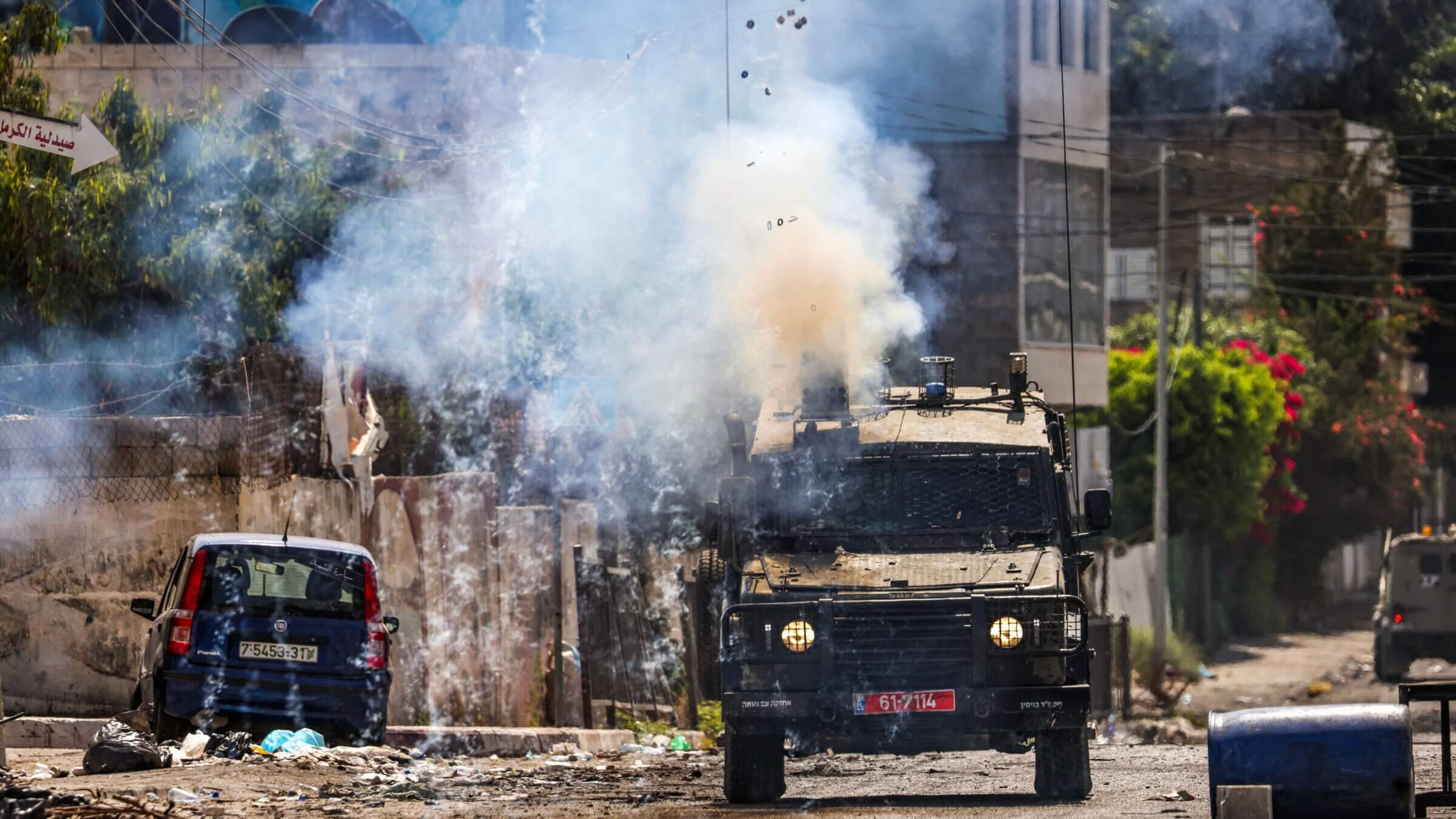 Israeli soldiers fire tear gas canisters from an armored vehicle during an ongoing military operation in the occupied West Bank city of Jenin on July 4, 2023