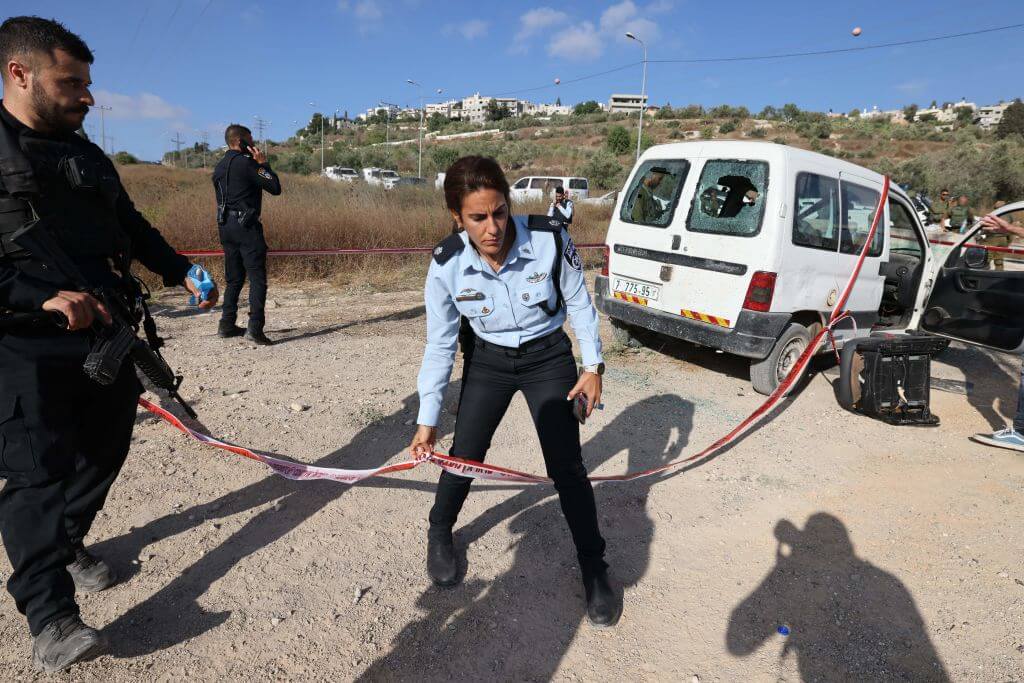 Israeli soldiers secure the area around a damaged car following an attack in the Kdumim settlement, in the occupied West Bank on July 6, 2023. 