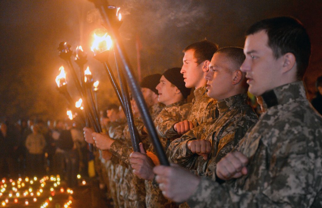 Soldiers lined up holding torches.