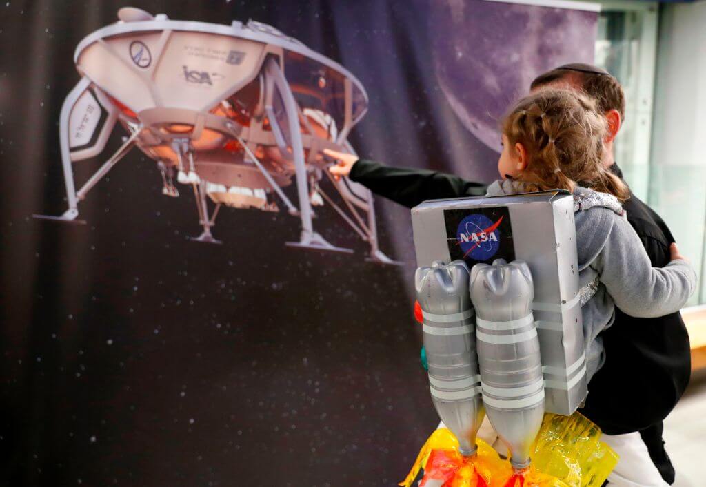 An Israeli child looks at a poster of <i>Beresheet</i> at the Planetaya Planetarium in the Israeli city of Netanya, on April 11, 2019, before it crashed during the landing.