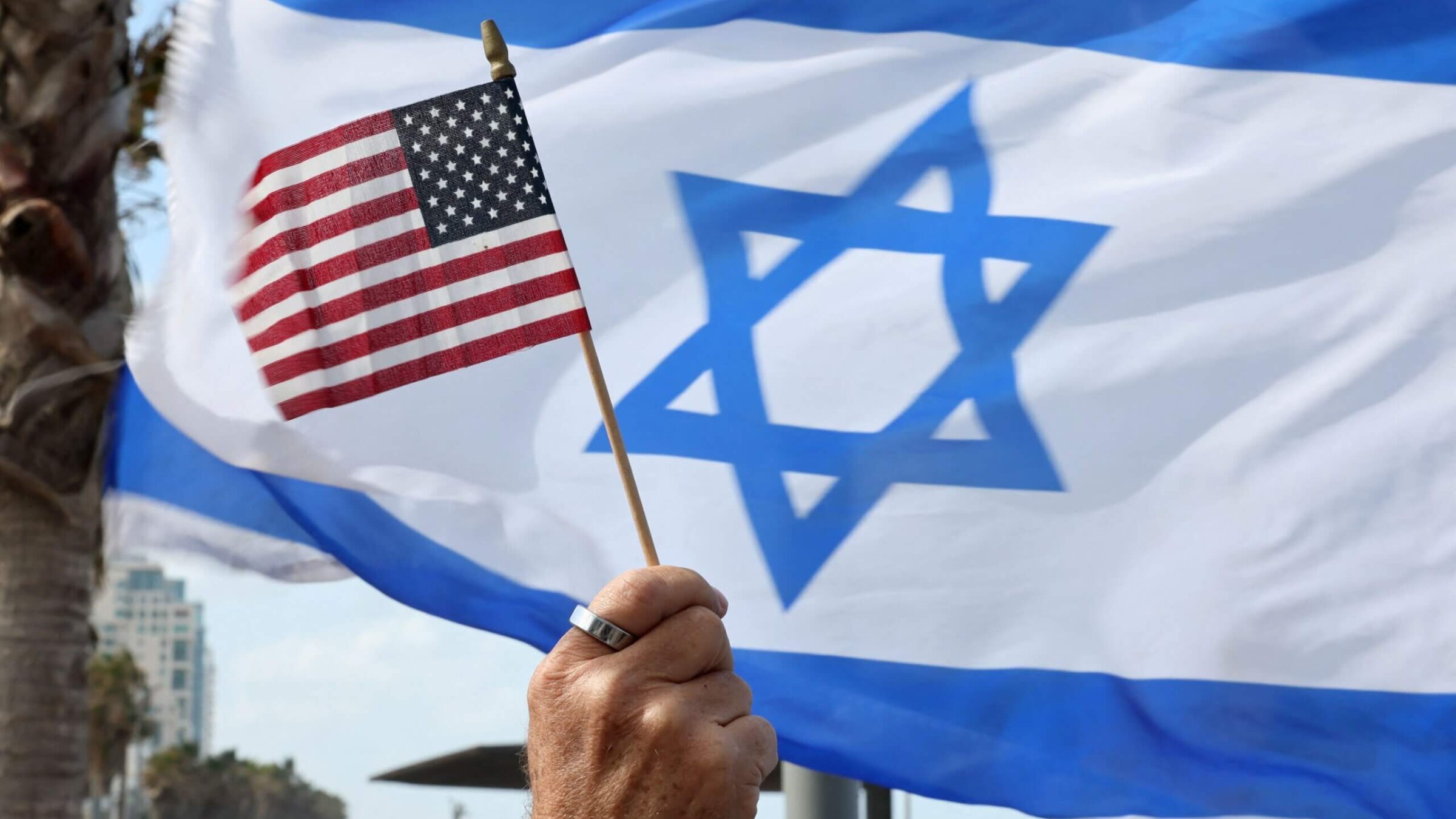 Israelis raise American and Israeli flags outside the U.S. Embassy in Tel Aviv on March 30, 2023.