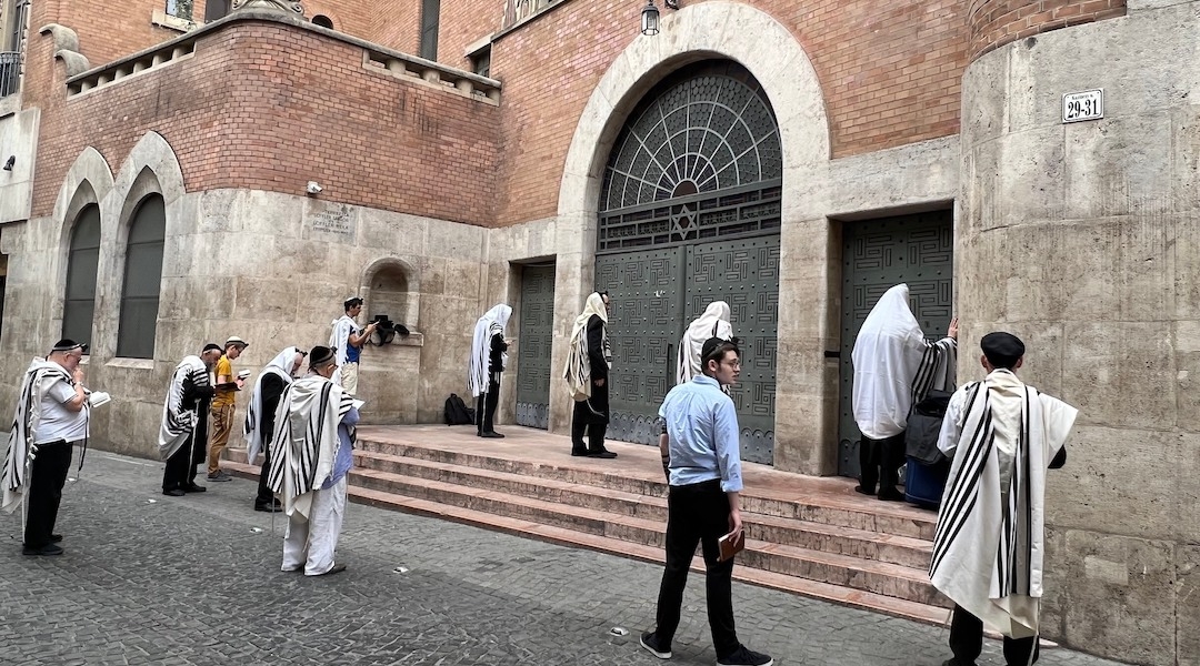 Worshippers hold morning services outside the locked doors of the Kazinczy Street Synagogue in Budapest, Hungary, July 21, 2023. (David Kelsey)