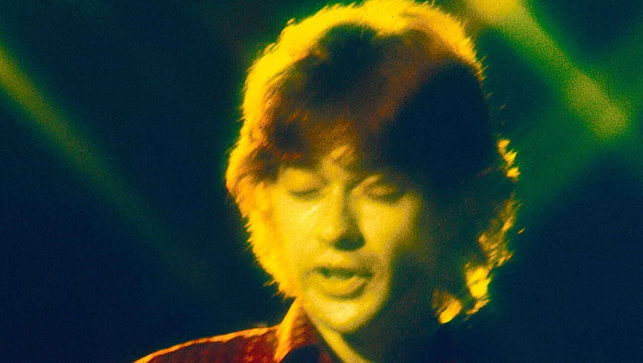 Robbie Robertson performs with The Band and Bob Dylan in 1974.