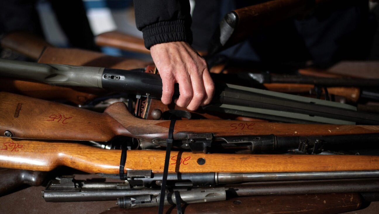 A police officer moves a rifle during a gun buyback program in Houston, Texas, Feb. 18, 2023. (Mark Felix/AFP via Getty Images)