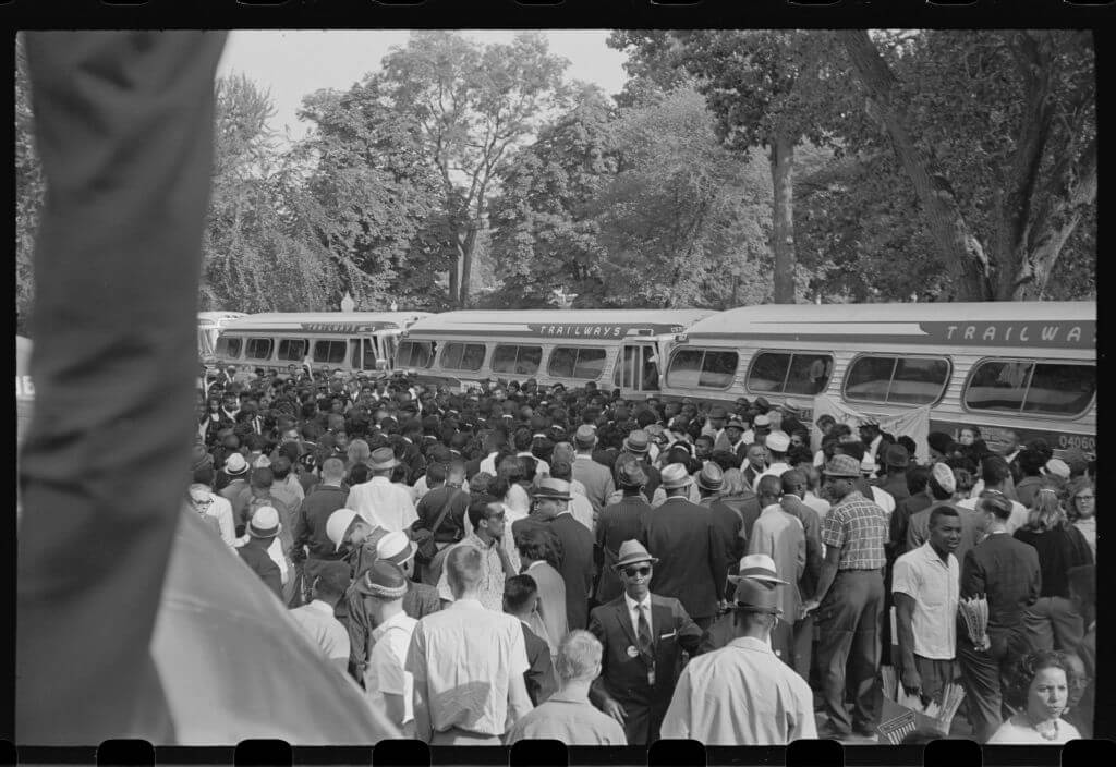Elevated view of a crowd of Civil Rights demonstrators beside parked buses during the March on Washington for Jobs and Freedom, Washington DC, August 28, 1963. Rachelle Horowitz, then 24, was the transportation coordinator for the march. (Photo by Roosevelt H. Carter/Getty Images)