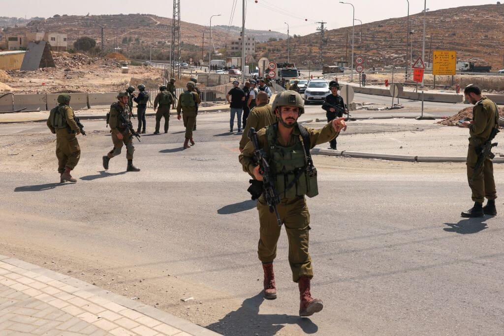 Israeli security forces block a road leading to the site of an attack south of Hebron in the occupied West Bank, on August 21, 2023. 
