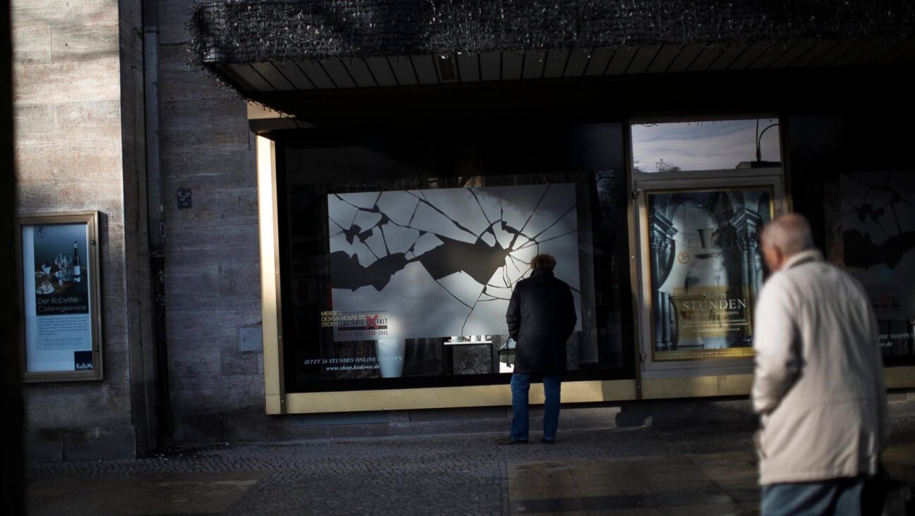 People walk past a Berlin window display commemorating the Kristallnacht pogroms. (Getty)