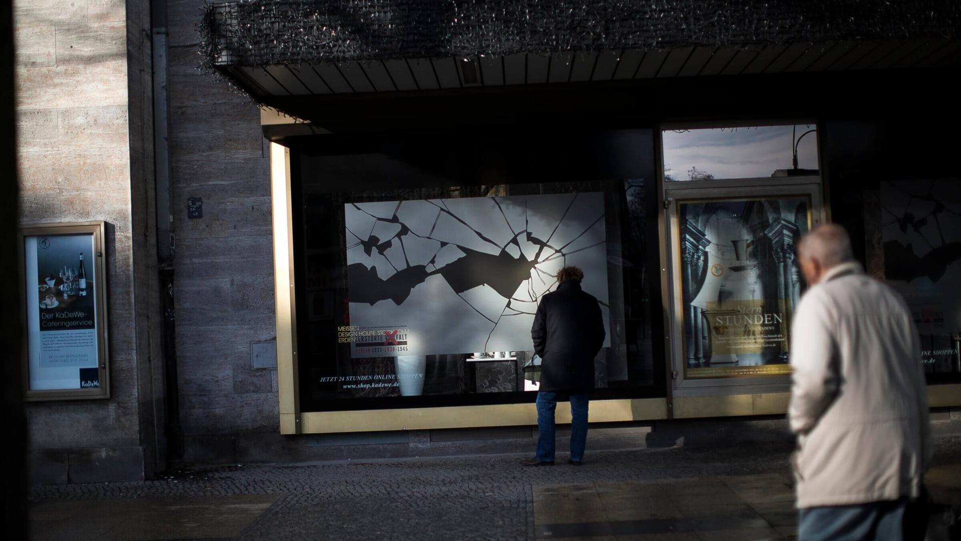 People walk past a Berlin window display commemorating the Kristallnacht pogroms. (Getty)