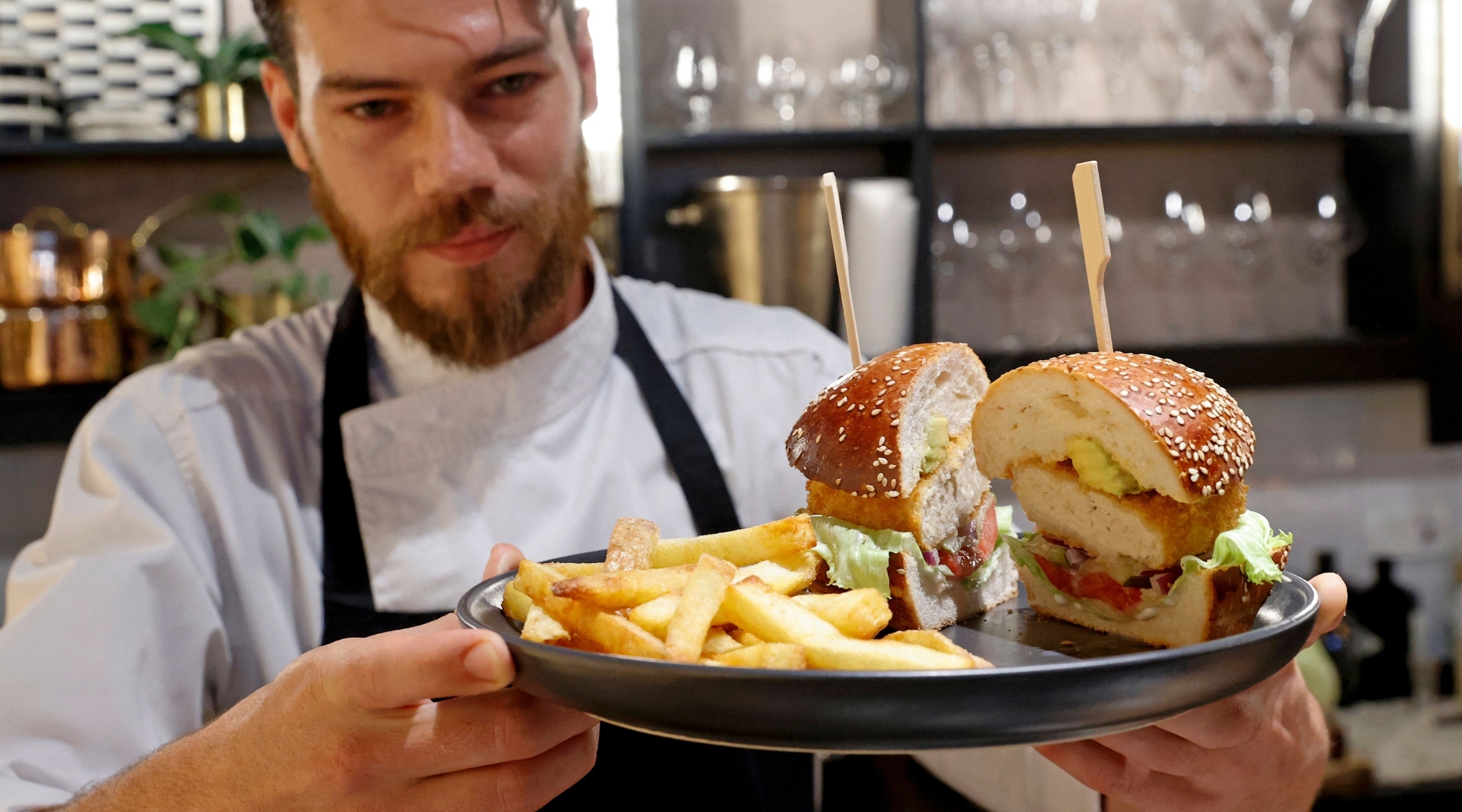 Israeli chef Shachar Yogev serves a burger made with “cultured chicken” meat at The Chicken, SuperMeat’s restaurant adjacent to their production site in the Israeli town of Ness Ziona on June 18, 2021. (Photo by JACK GUEZ/AFP via Getty Images)
