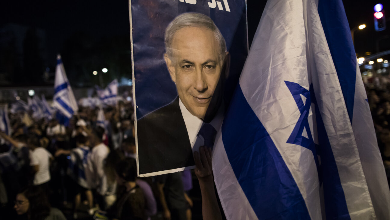 A woman holds a placard with a photo of Israeli Prime Minister Binyamin Netanyahu as the right wing holds a rally to support the government's judicial overhaul on July 23, 2023 in Tel Aviv.
