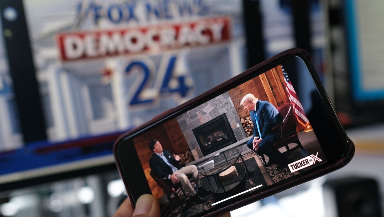 Tucker Carlson's interview of former US President Donald Trump on a smartphone ahead of the GOP debate in Milwaukee on August 23, 2023