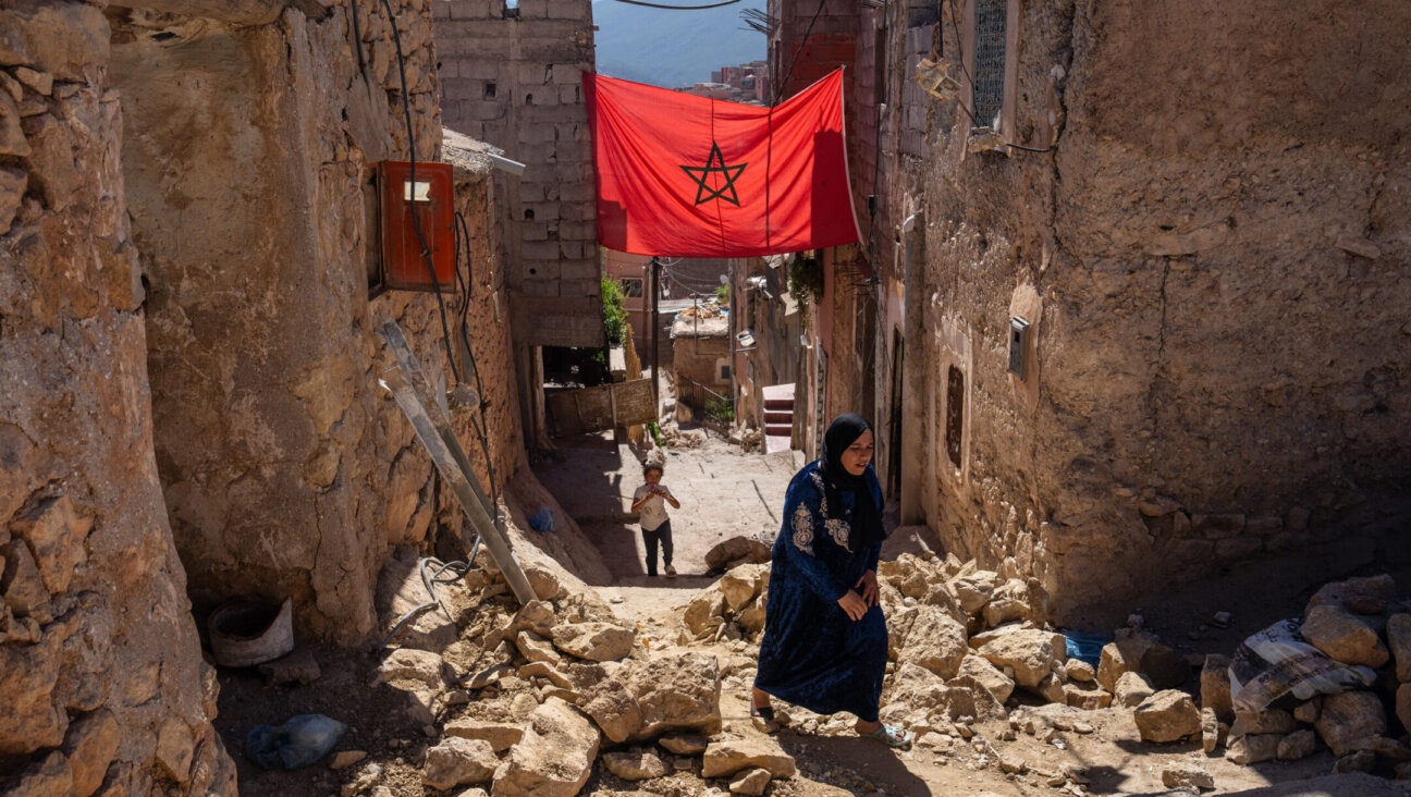 A woman walks past the rubble of damaged buildings following the Sept. 8 earthquake in Moulay Brahim, Morocco. (Carl Court/Getty Images)