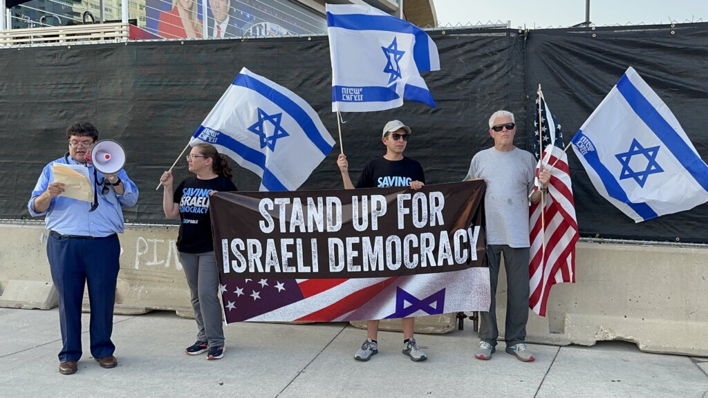 Protesters with the group UnXeptable talk about Israeli democracy outside the GOP presidential candidate debate in Milwaukee 