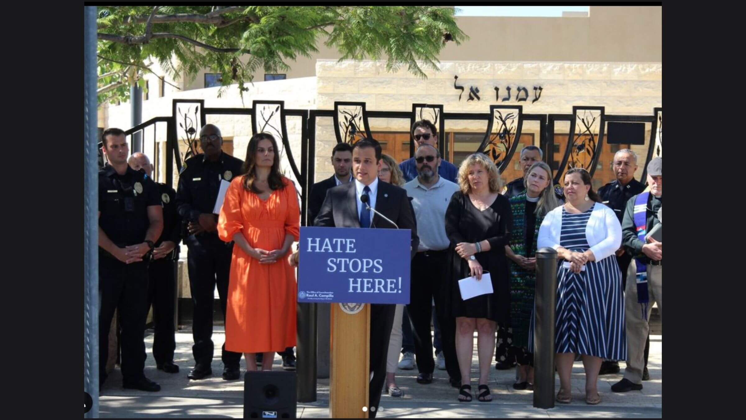 San Diego City Councilman Raul Campillo, standing at the podium, discusses a proposal to increase penalties for 'hate litter' at a news conference.