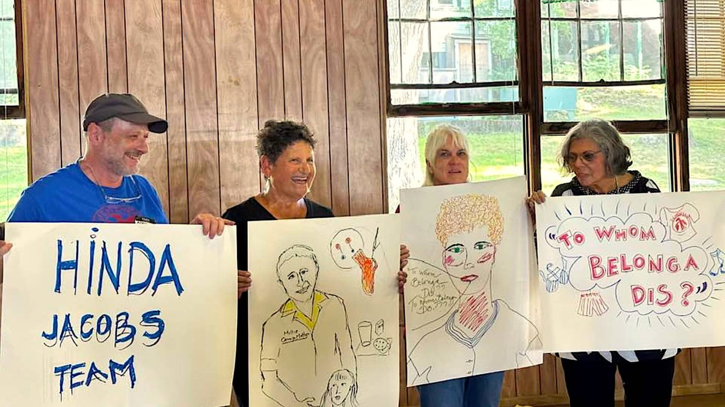 Members of the Hinda Jacobs team display the posters they had created, during the Camp Hemshekh reunion