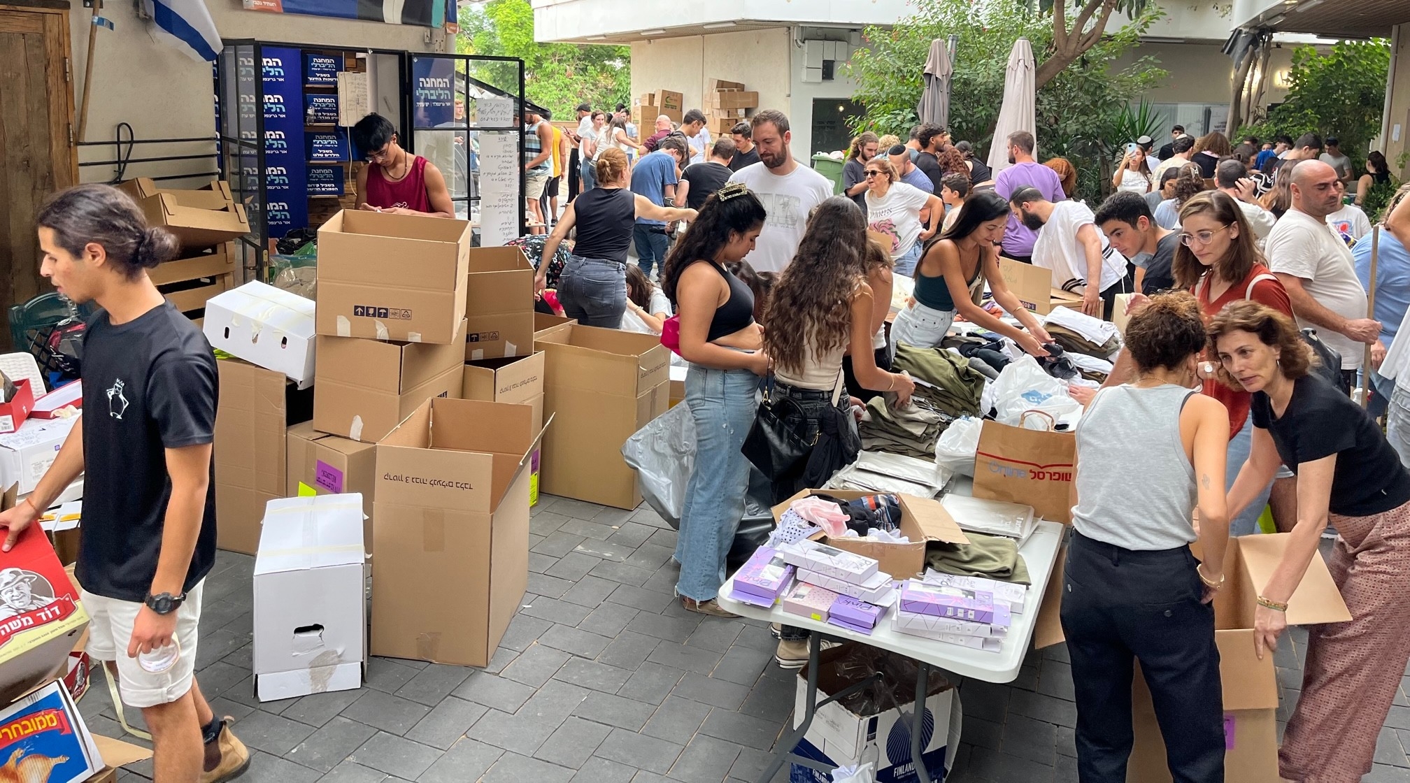 Volunteers at a shopping center in the Maccabim neighborhood of Modiin, Israel, collecting and packaging supplies for soldiers, including soap, shampoo, deodorant, canned tuna, energy bars, underwear, socks, toothbrushes and female hygiene products, Oct. 9, 2023. (Uriel Heilman)