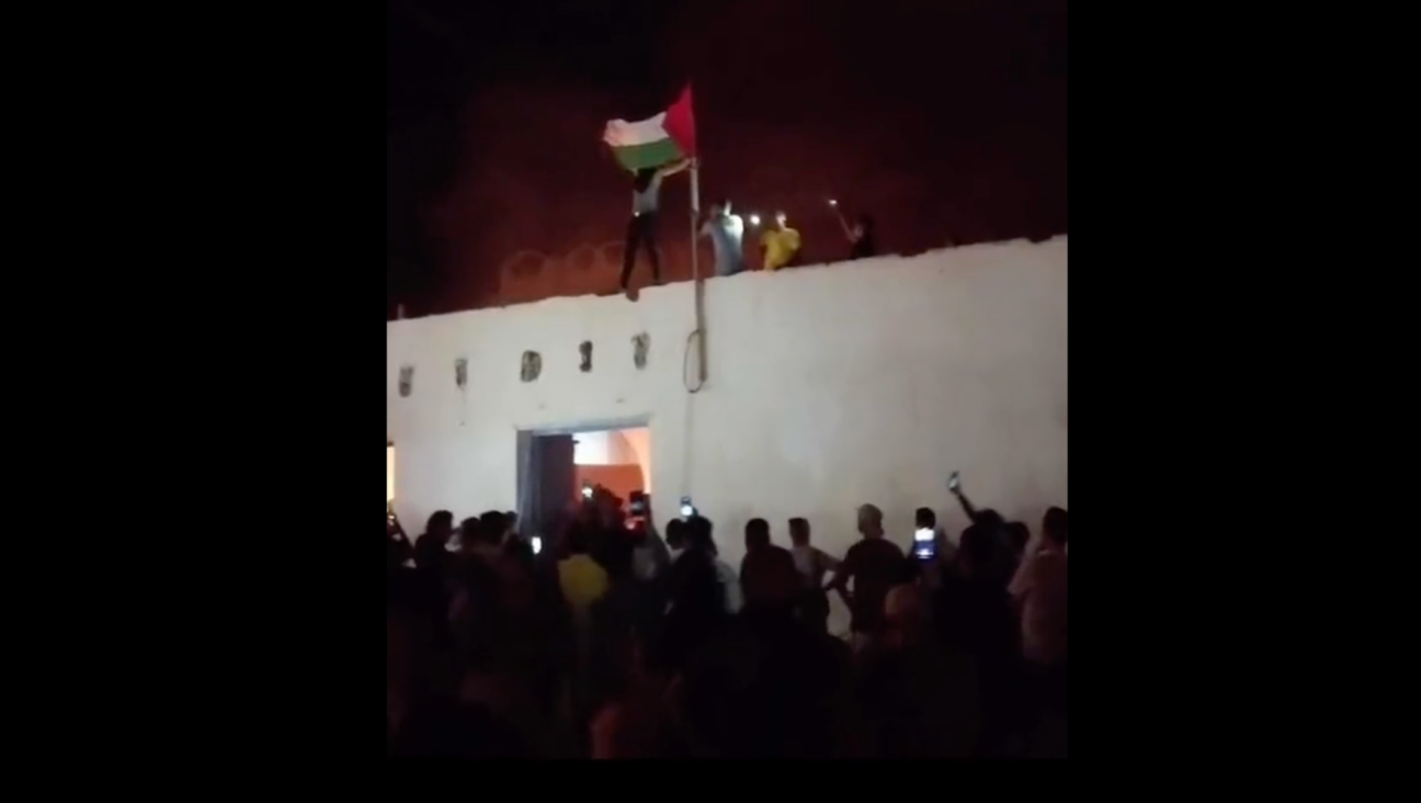 Tunisian protesters fly a Palestinian flag as a historic synagogue in Al Hammah burns, Oct. 17, 2023. (Screenshot via X)