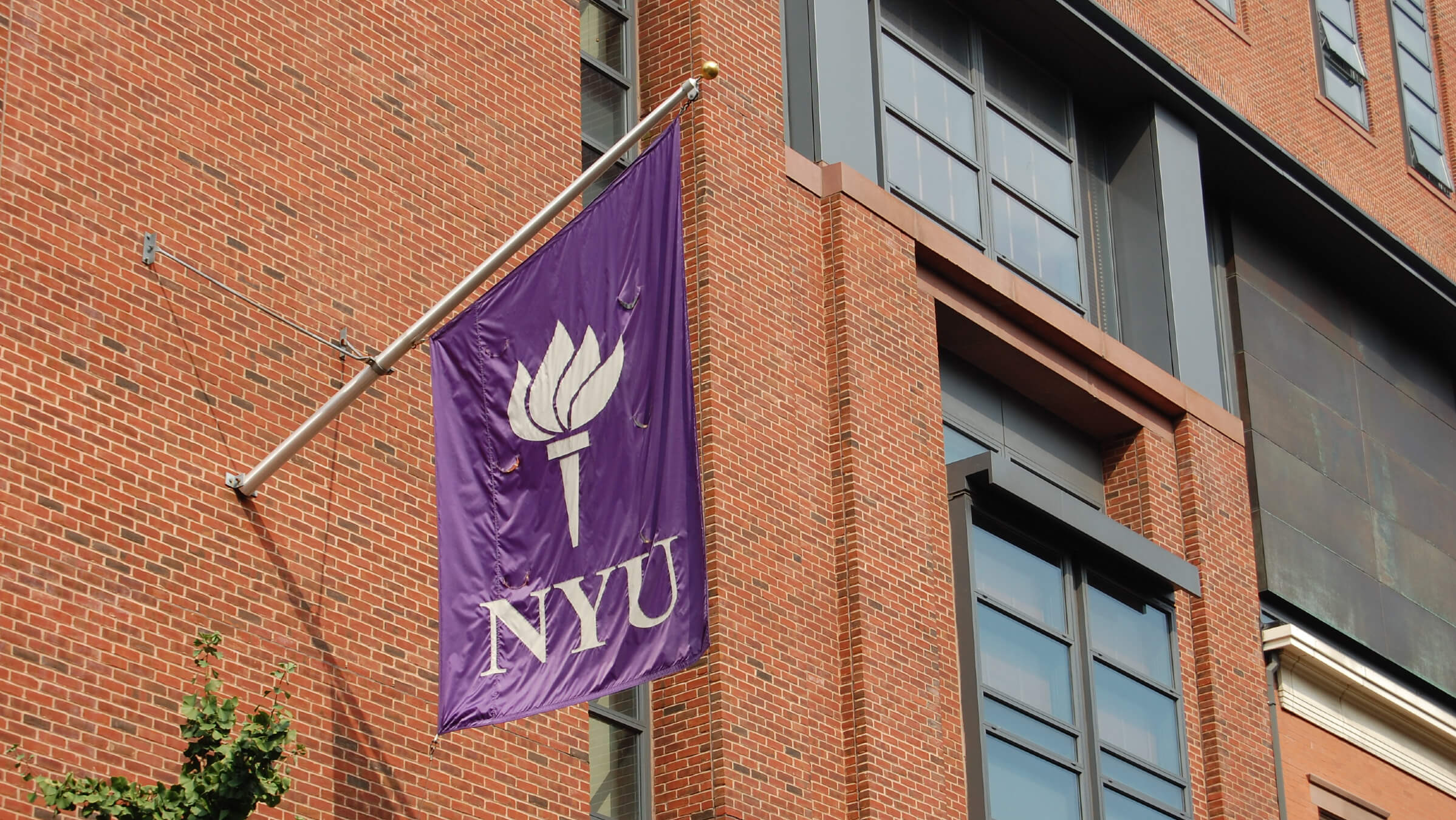 The New York University flag flies on a campus building.