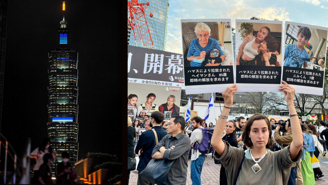 Taipei 101, a landmark building in Taiwan, is illuminated in blue and white to support Israel, while a woman holds up Japanese-language posters featuring Israelis who have been taken hostage by Hamas during a rally in Tokyo, Oct. 11, 2023. (Sam Yeh/AFP via Getty Images, Twitter)