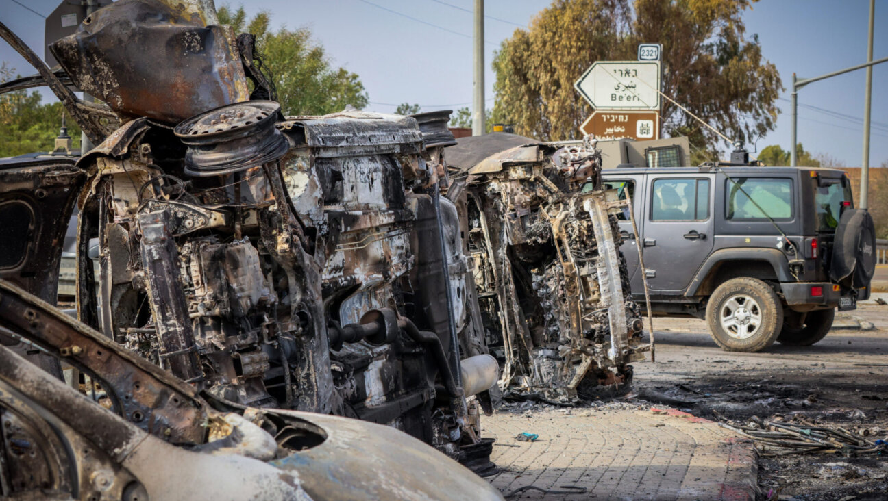 Israeli security seen next to burnt cars at the entrance to Kibbutz Be’eri, near the Israeli-Gaza Border, in southern Israel, Oct. 9, 2023. (Yossi Zamir/Flash90) רחבות ברזל