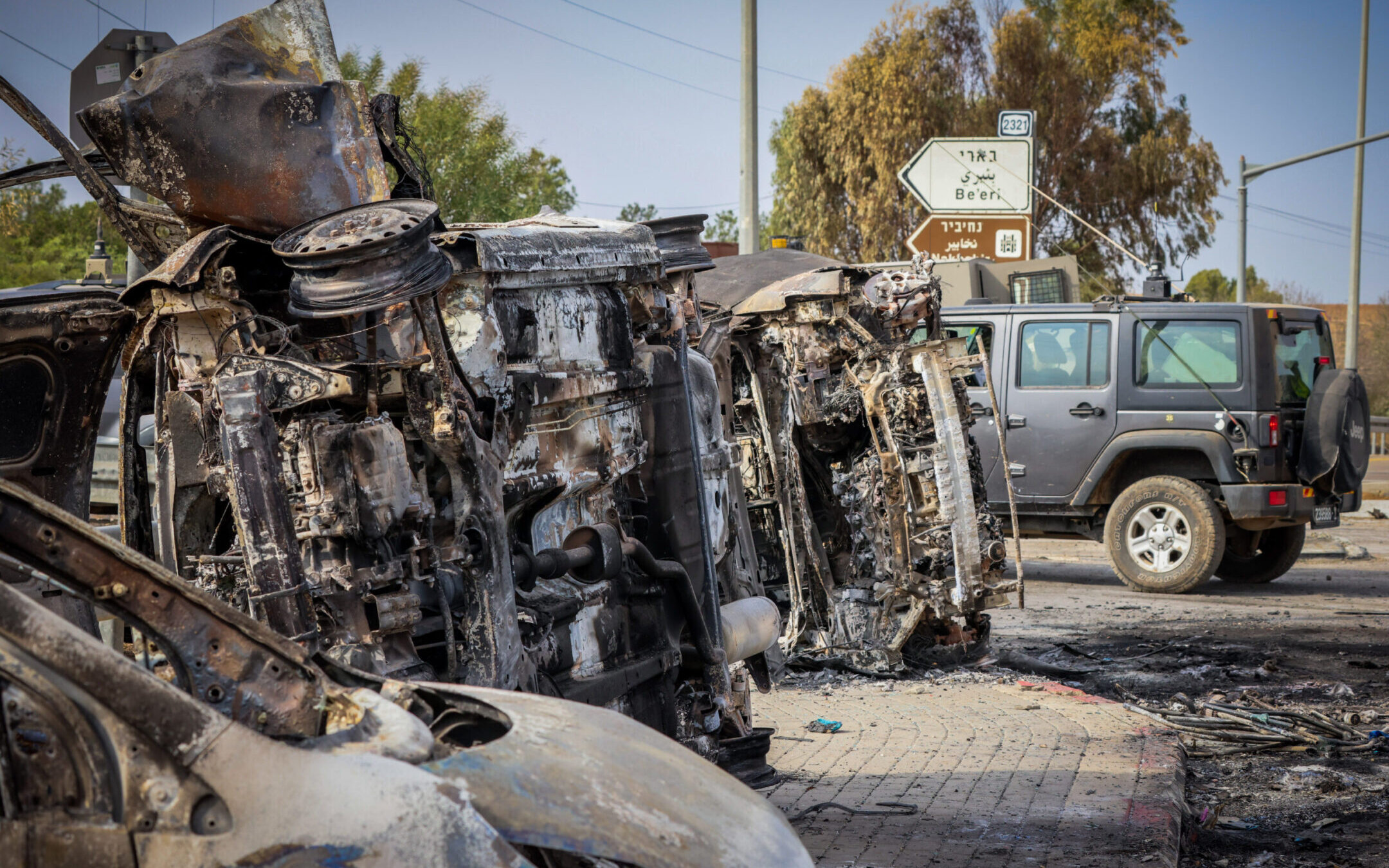 Israeli security seen next to burnt cars at the entrance to Kibbutz Be’eri, near the Israeli-Gaza Border, in southern Israel, Oct. 9, 2023. (Yossi Zamir/Flash90) רחבות ברזל