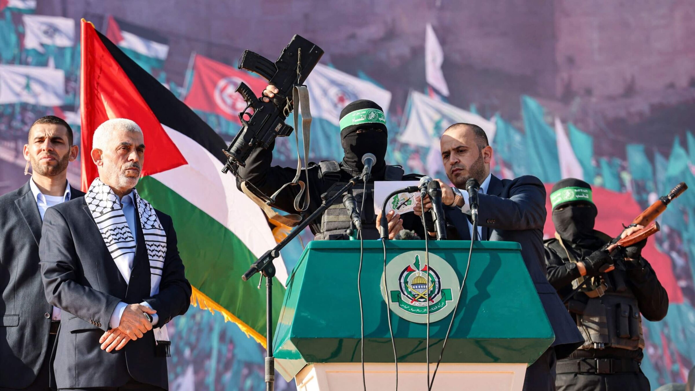 Yahia al-Sinwar, <i>second from left</i>, the current Hamas leader, stands by as a masked Hamas fighter holds up a firearm that reportedly belonged to Israeli soldier Hadar Goldin — whose body is believed to have been held by Hamas since 2014 — during a 2022 rally marking the 35th anniversary of the terrorist group's foundation.
